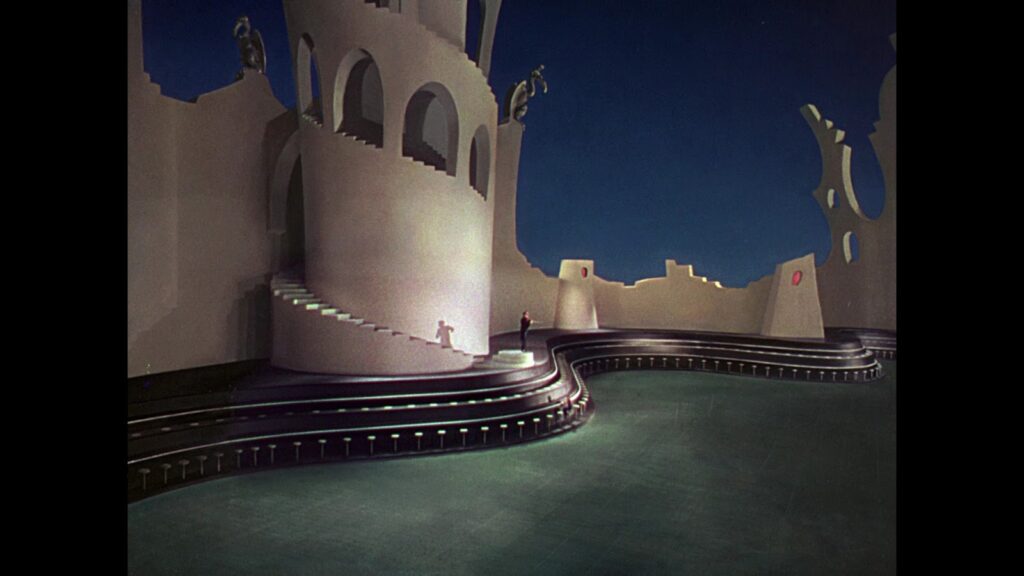 Long shot of expressionistic bare Suessian movie set. 